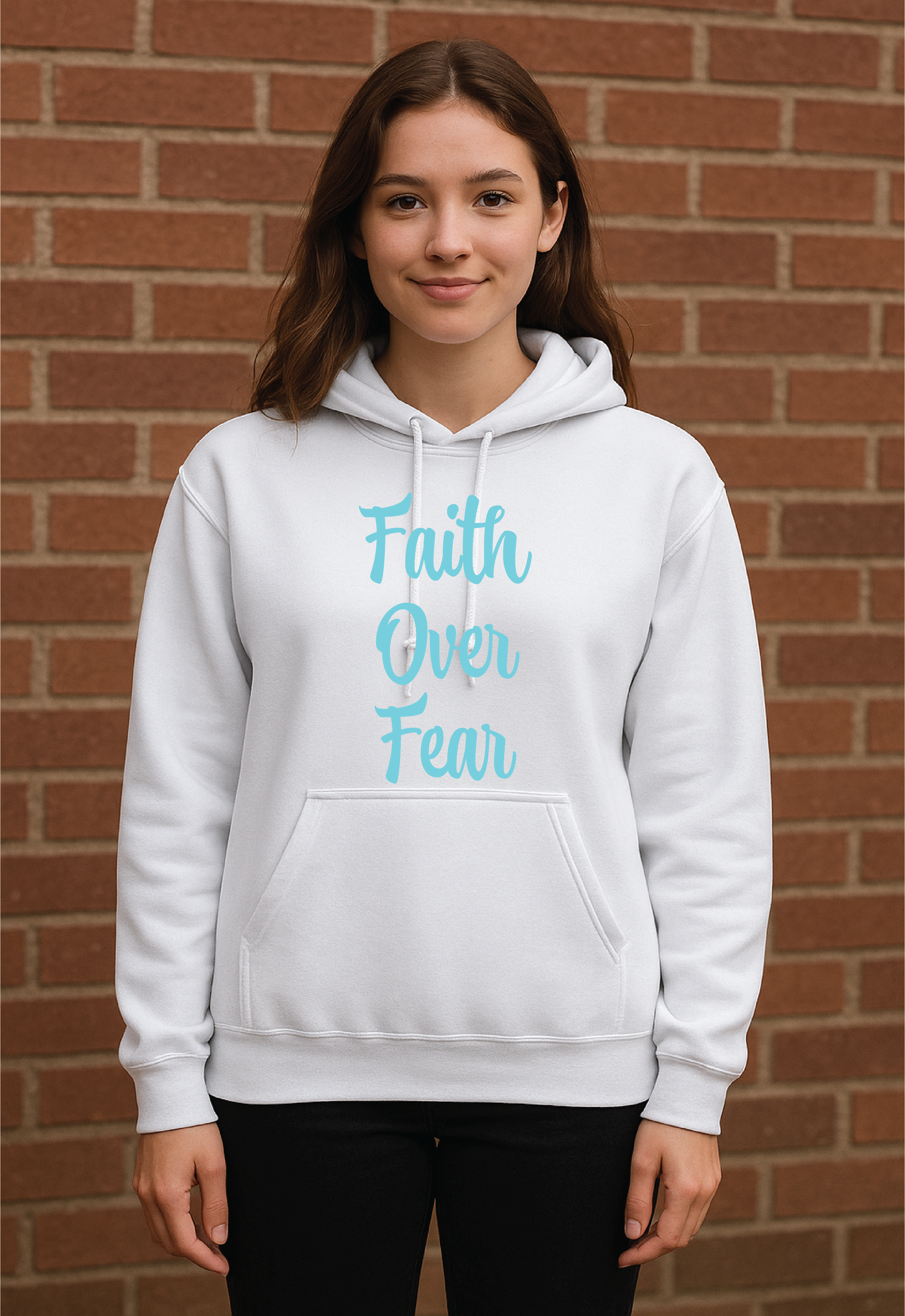 Person wearing a white hoodie with 'Faith Over Fear' text in blue against a brick wall.
