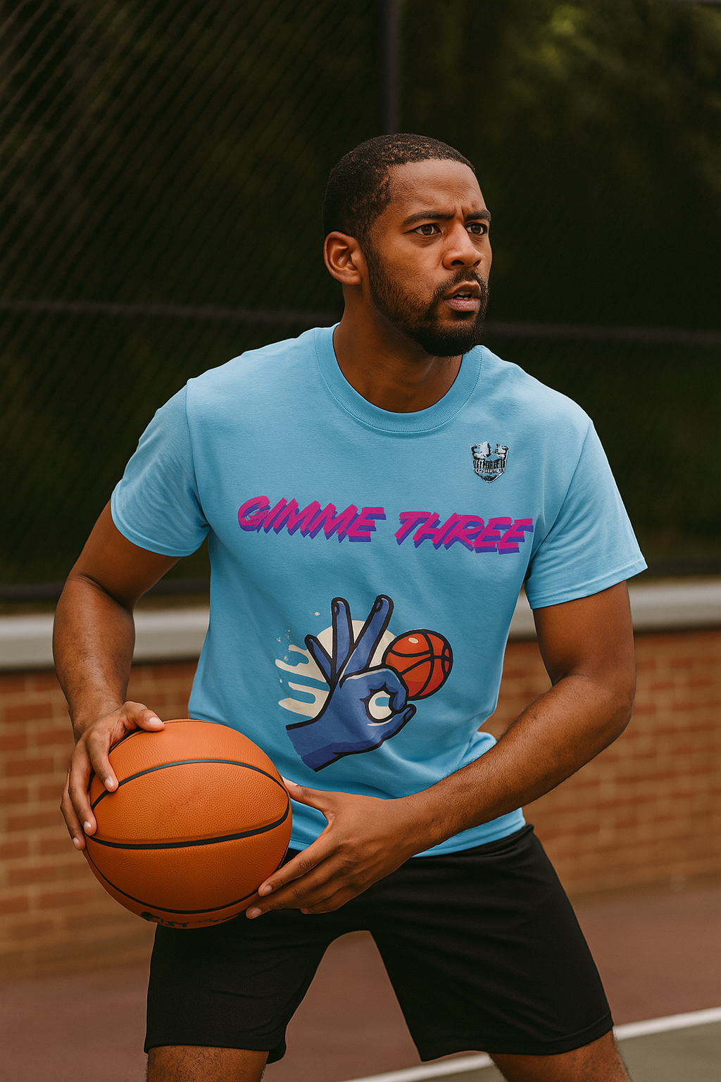 Man holding a basketball wearing a blue t-shirt with graphic design and text.